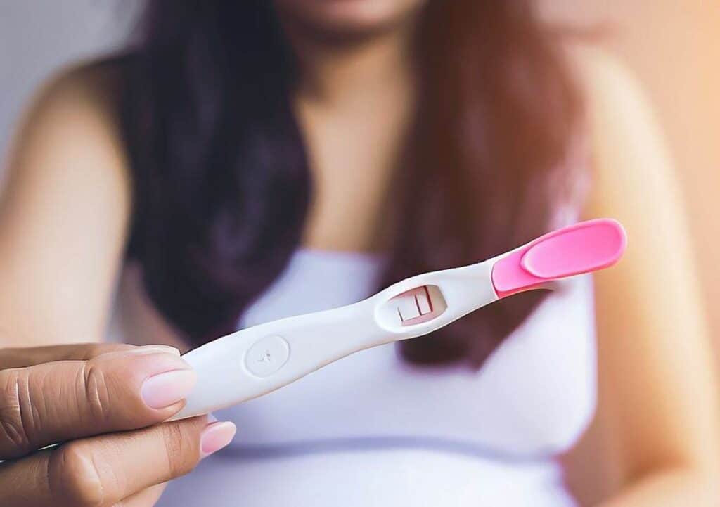 femme avec un test de grossesse